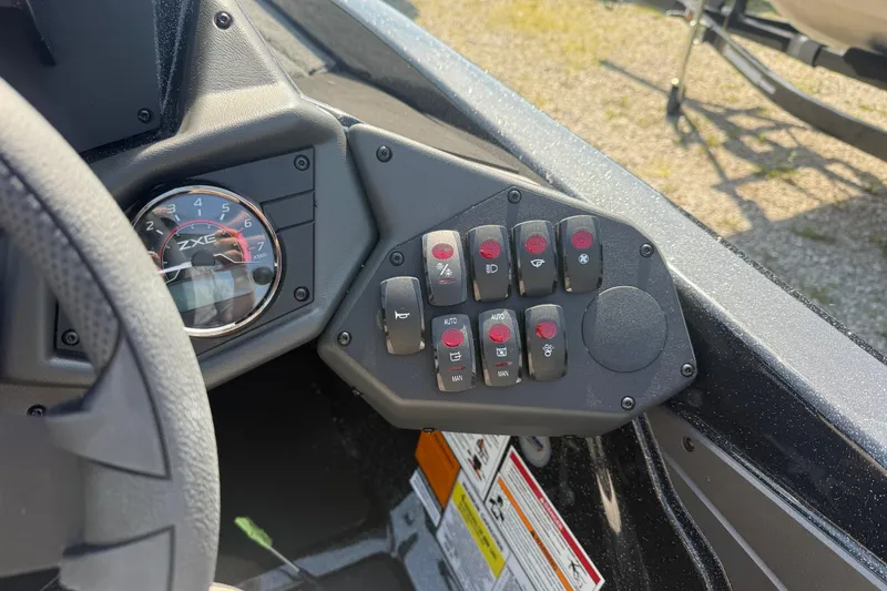 Slide: The Image of Control panel of 2026 Skeeter ZXE21 boat with switches and tachometer. - 13