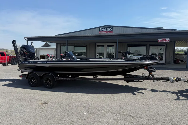 Slide: The Image of 2026 Skeeter ZXE21 boat on trailer outside Anglers Outpost & Marine dealership. - 3