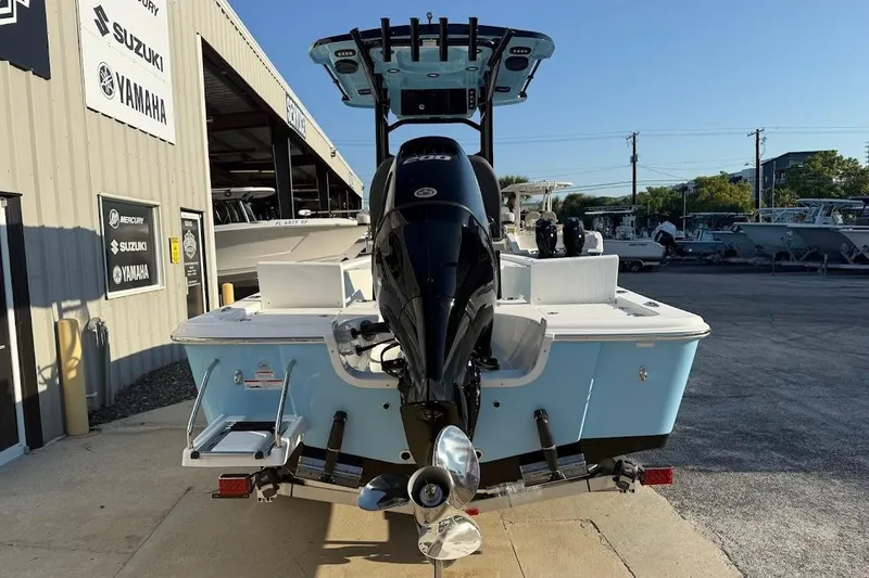 Slide: The Image of 2026 Sea Pro 230 Bay boat with outboard motor at dealership, featuring Suzuki and Yamaha signage. - 6