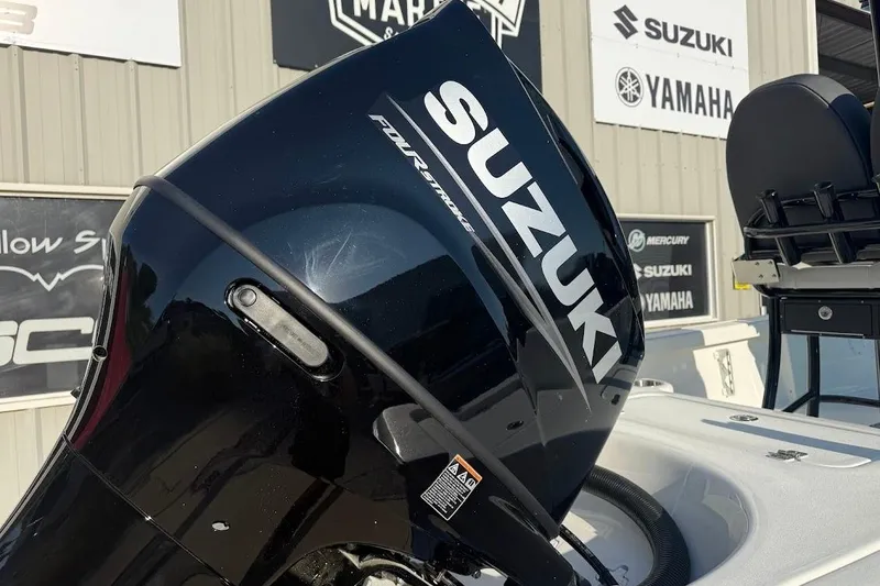 Slide: The Image of Suzuki outboard motor on a 2026 Sea Pro 230 Bay boat, displayed at a dealership. - 9