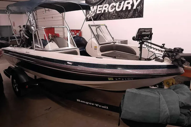 The Image of 2012 Ranger 1850MS Reata boat with canopy and trailer in a garage setting. - 1
