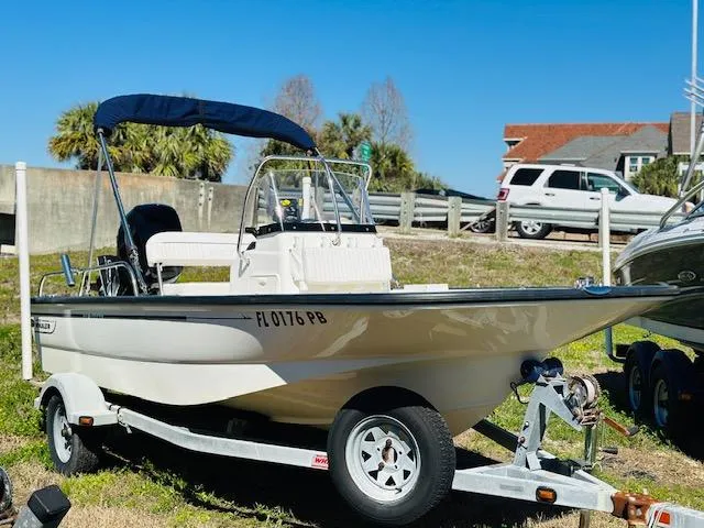 The Image of 2010 Boston Whaler 150 Montauk boat on trailer, parked outdoors under clear blue sky. - 1
