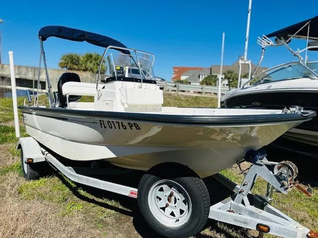 Slide: The Image of 2010 Boston Whaler 150 Montauk boat on trailer, parked outdoors under clear blue sky. - 3