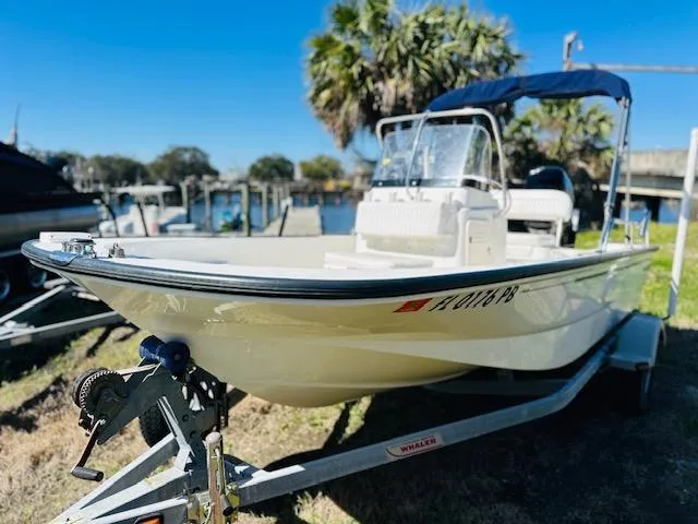 Slide: The Image of 2010 Boston Whaler 150 Montauk boat on trailer, near waterfront with palm trees. - 4
