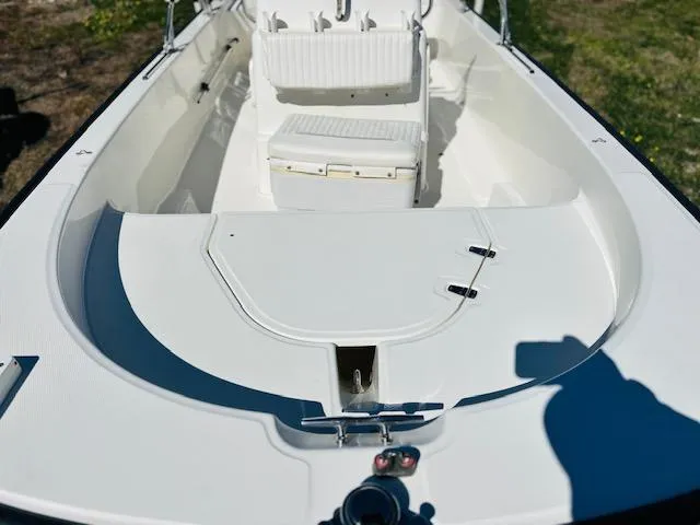Slide: The Image of 2010 Boston Whaler 150 Montauk boat interior, featuring white seating and clean deck design. - 5