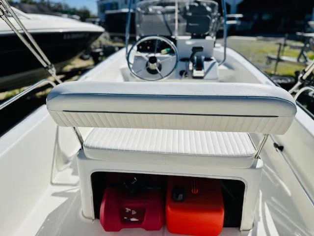 Slide: The Image of 2010 Boston Whaler 150 Montauk boat interior with steering wheel and storage compartment. - 9
