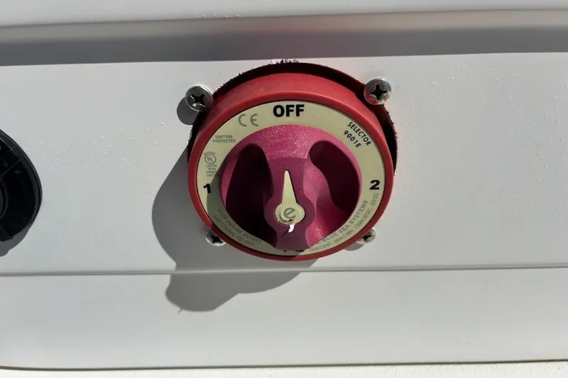 Slide: The Image of Red battery selector switch on a Ranger Banshee 2009, showing off, 1, and 2 positions. - 10