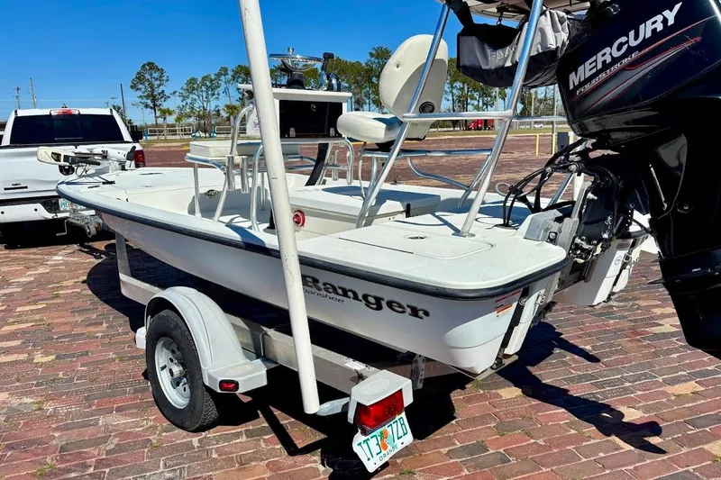 Slide: The Image of 2009 Ranger Banshee boat on trailer with Mercury engine, parked on brick pavement. - 17