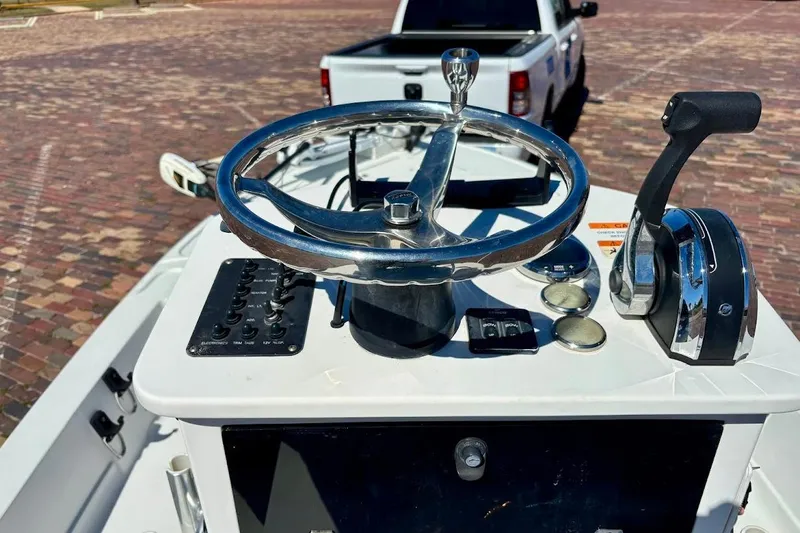 Slide: The Image of 2009 Ranger Banshee boat helm with steering wheel and controls, parked truck in background. - 27
