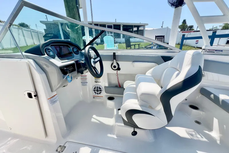 Slide: The Image of 2023 Chaparral 23 SSi OB boat interior with steering wheel and white seating. - 13