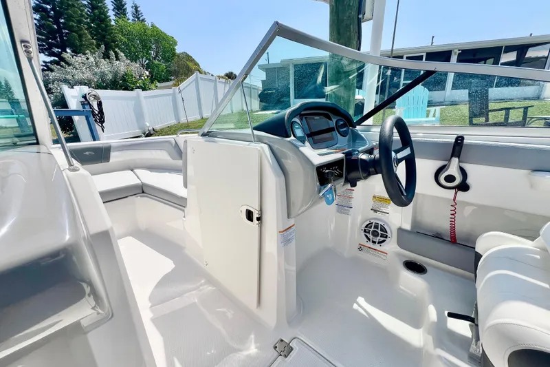 Slide: The Image of 2023 Chaparral 23 SSi OB boat interior with steering wheel and seating area. - 14