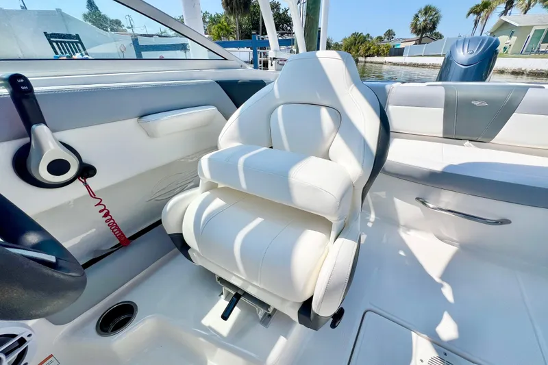 Slide: The Image of 2023 Chaparral 23 SSi OB boat interior with white seating and control panel. - 16