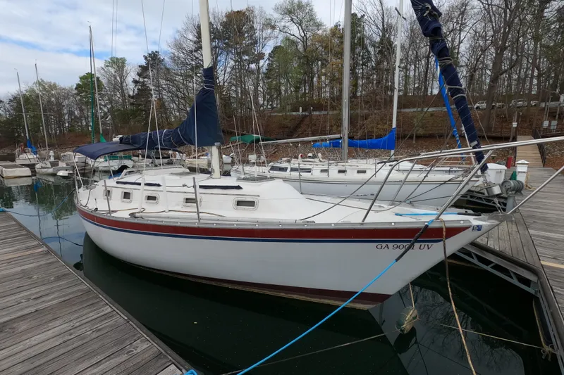 The Image of 1982 Irwin 34 Citation sailboat docked at a marina, surrounded by trees. - 0
