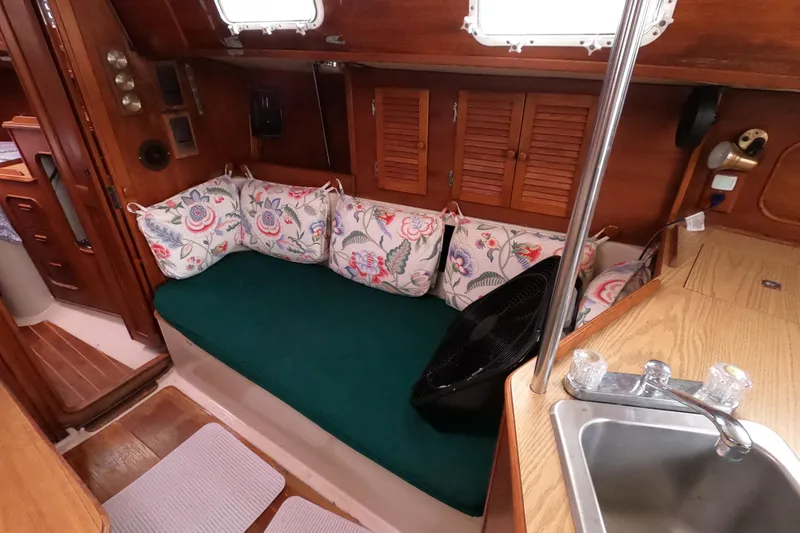 Slide: The Image of Interior of 1982 Irwin 34 Citation sailboat with floral cushions and wooden cabinetry. - 13