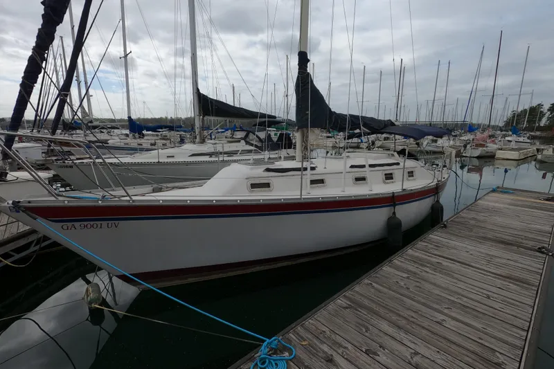Slide: The Image of 1982 Irwin 34 Citation sailboat docked at a marina, surrounded by other boats. - 2
