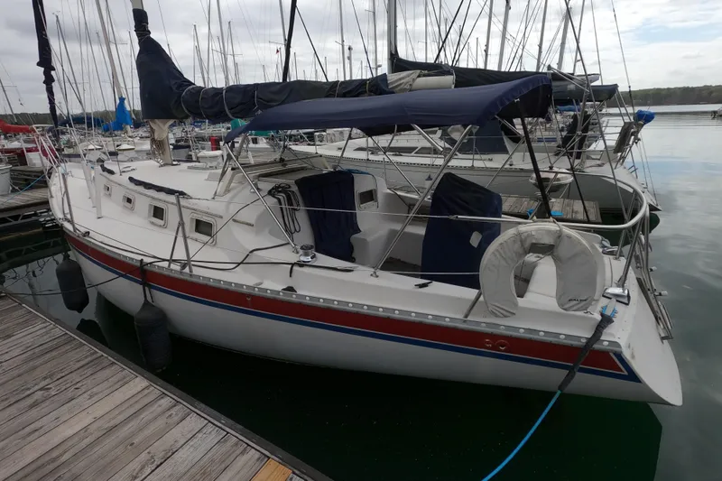 Slide: The Image of 1982 Irwin 34 Citation sailboat docked at marina with blue canopy. - 3