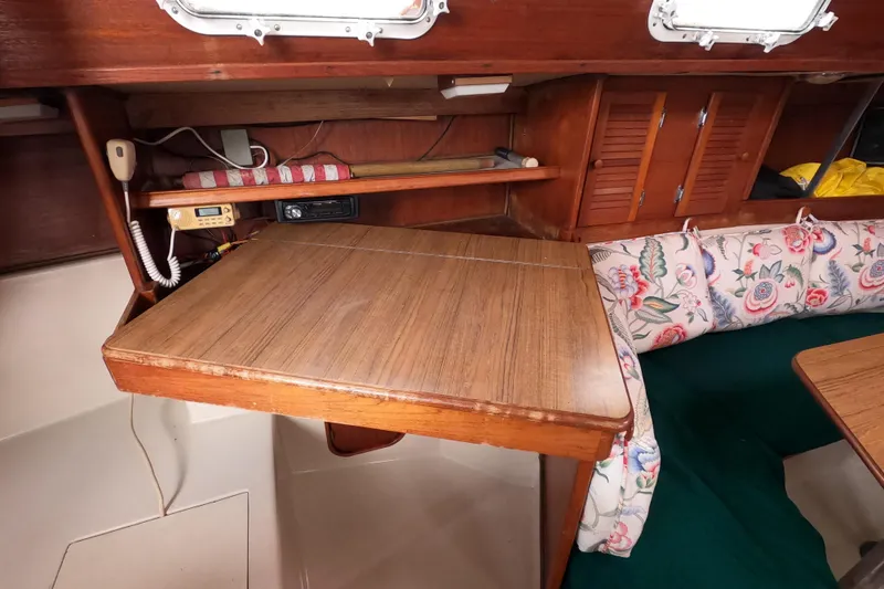 Slide: The Image of Interior of 1982 Irwin 34 Citation sailboat with wooden table and floral cushions. - 9