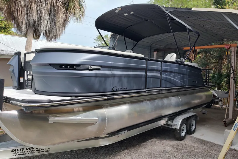 The Image of 2026 Sylvan G3 CLZ DH pontoon boat on trailer under canopy. - 0