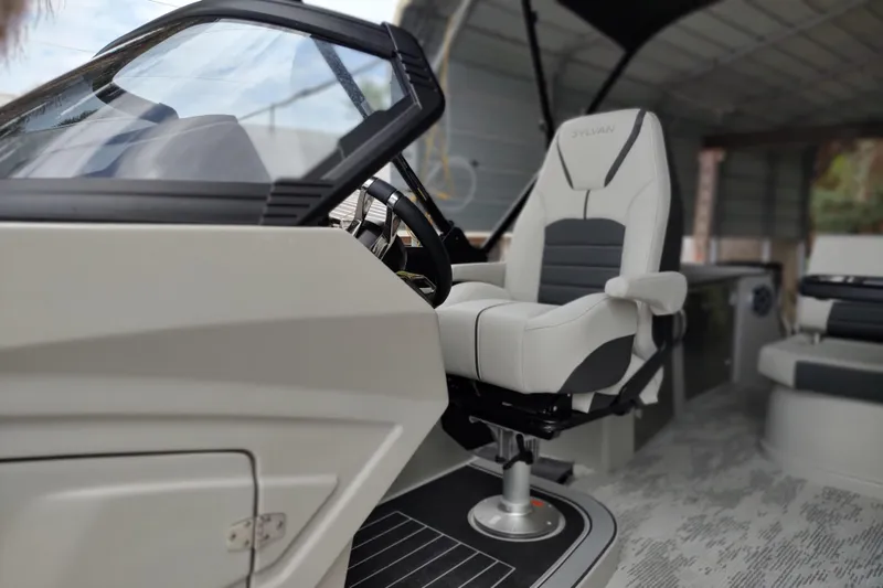 Slide: The Image of 2026 Sylvan G3 CLZ DH boat interior with modern captain's chair and sleek dashboard design. - 13