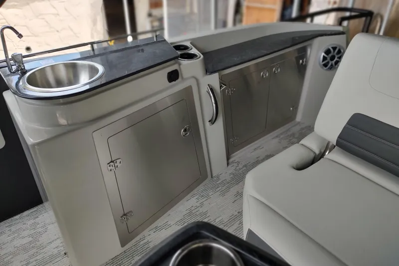 Slide: The Image of 2026 Sylvan G3 CLZ DH boat interior with sink, storage cabinets, and seating area. - 4