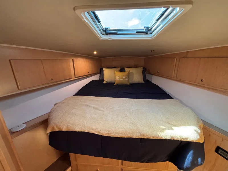 Slide: The Image of Cozy bedroom in 2000 Navigator 5300 yacht with skylight and wooden cabinets. - 22