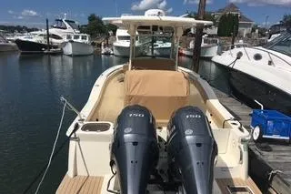 Slide: The Image of 2018 Scout 255 LXF boat docked with twin engines in a marina. - 2