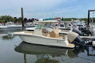 Slide: The Image of 2018 Scout 255 LXF boat docked in a marina with other vessels. - 3