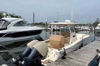 Slide: The Image of 2018 Scout 255 LXF boat docked at marina with twin outboard engines. - 6
