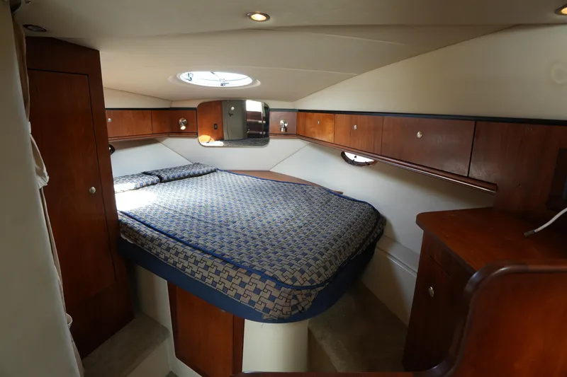 Slide: The Image of Luxurious cabin interior of 2005 Cruisers Yacht 340 Express with cozy bed and wooden cabinetry. - 14