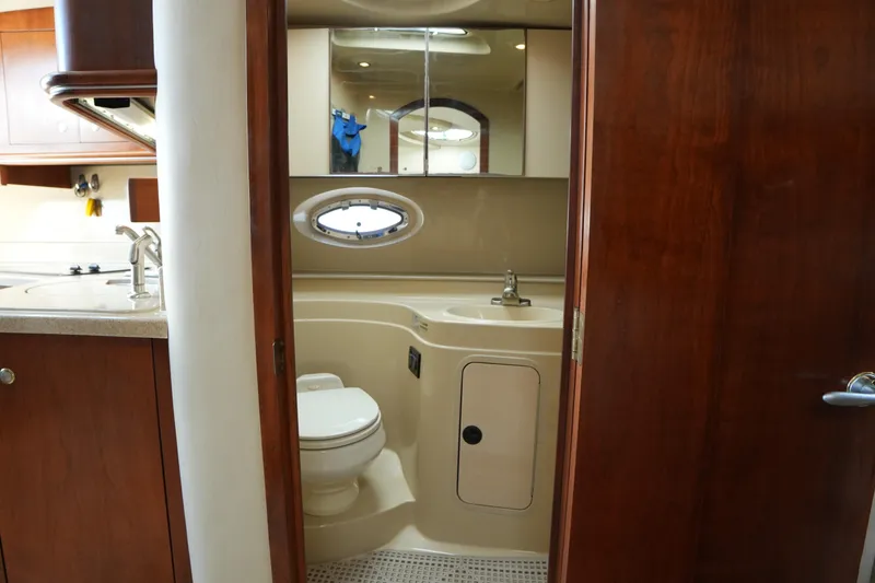 Slide: The Image of 2005 Cruisers Yacht 340 Express bathroom interior with sink, toilet, and mirror. - 16