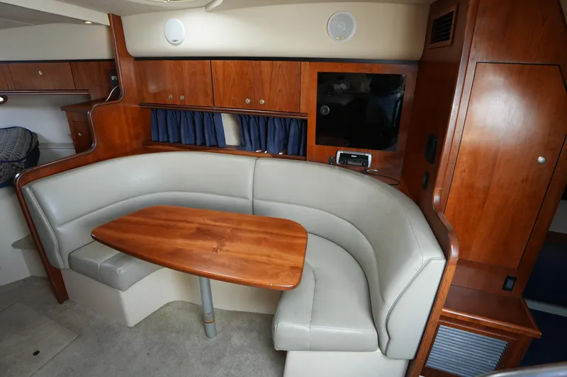 Slide: The Image of Interior of 2005 CRUISERS YACHT 340 Express with leather seating and wooden table. - 19