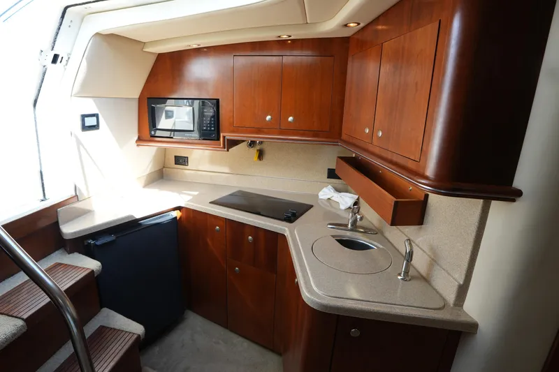 Slide: The Image of Luxurious 2005 Cruisers Yacht 340 Express kitchen with wood cabinets and modern appliances. - 21