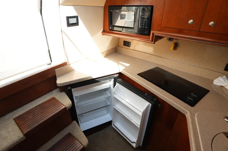 Slide: The Image of 2005 CRUISERS YACHT 340 Express kitchen with microwave, fridge, and stovetop. - 23