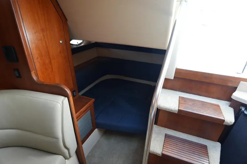 Slide: The Image of Interior of 2005 CRUISERS YACHT 340 Express, featuring cozy cabin and wooden accents. - 24