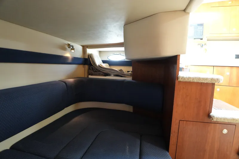 Slide: The Image of Interior cabin of 2005 Cruisers Yacht 340 Express with blue seating and wooden accents. - 25