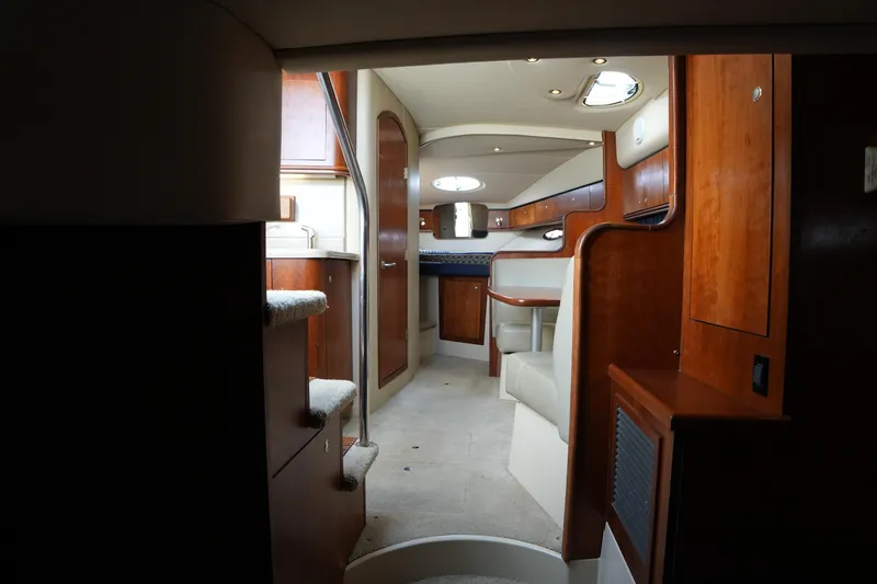 Slide: The Image of Interior of 2005 CRUISERS YACHT 340 Express, featuring elegant wood finishes and cozy seating. - 26