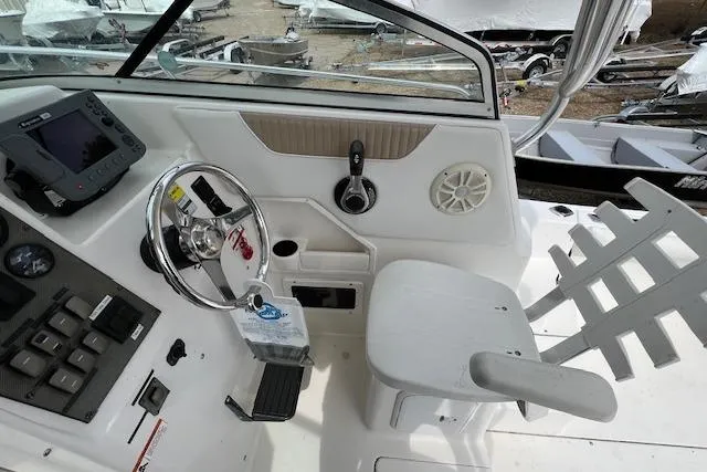 Slide: The Image of 2006 Striper 2301 Walkaround OB boat cockpit with steering wheel and control panel. - 16