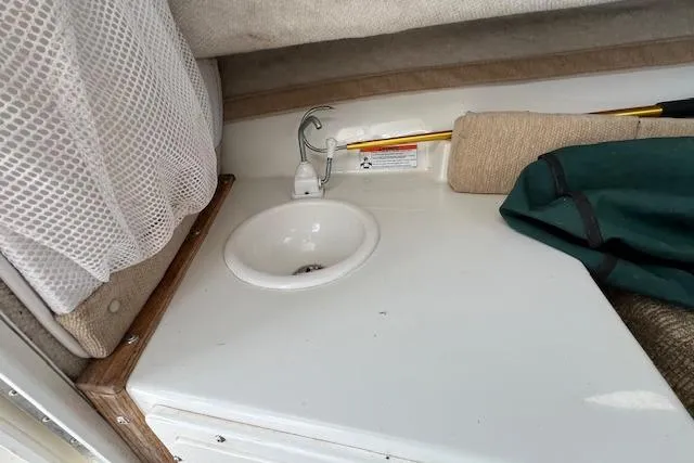 Slide: The Image of 2006 Striper 2301 Walkaround OB cabin sink area with storage and accessories. - 17