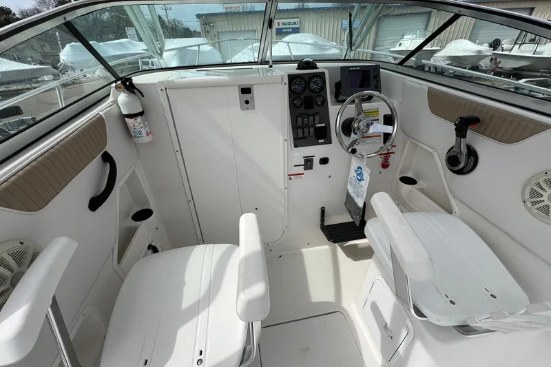 Slide: The Image of 2006 Striper 2301 Walkaround OB boat cockpit with steering wheel and control panel. - 22