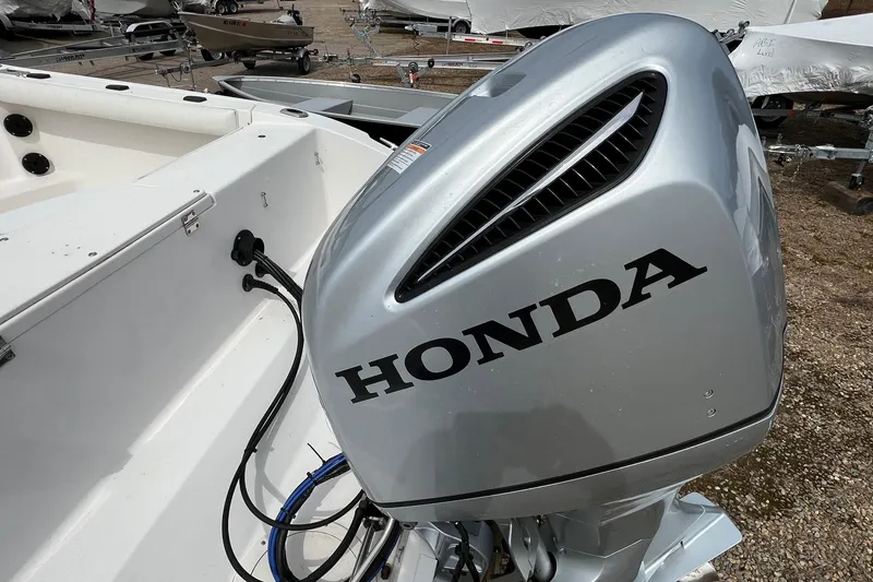 Slide: The Image of 2006 Striper 2301 Walkaround OB with Honda outboard motor in a boatyard. - 24