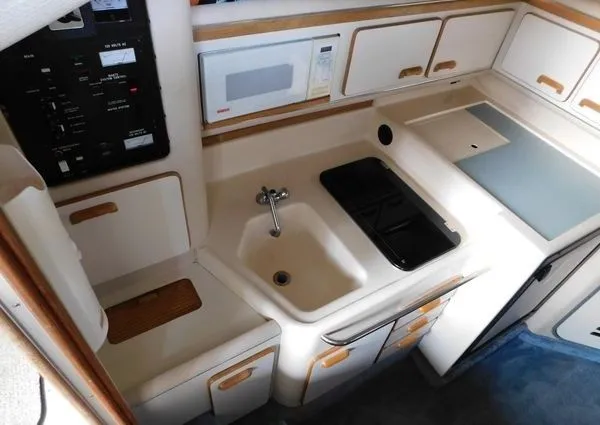 Slide: The Image of 1995 Sea Ray 330 Express Cruiser kitchen area with sink and microwave. - 13
