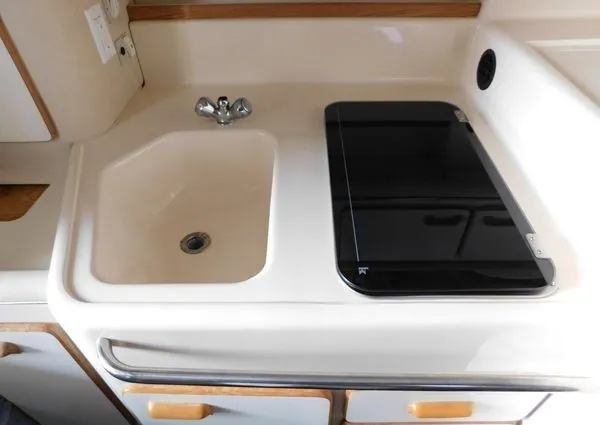 Slide: The Image of 1995 Sea Ray 330 Express Cruiser kitchenette with sink and stove. - 23