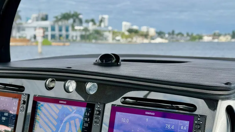 Slide: The Image of Dashboard of 2020 Fountain 43NX boat with navigation screens, overlooking waterfront view. - 23