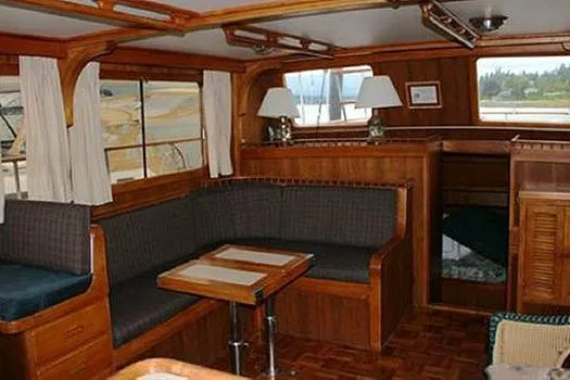 Slide: The Image of 1980 CHB Trawler interior with wooden decor, cozy seating, and nautical ambiance. - 12