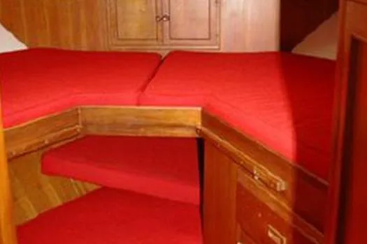 Slide: The Image of 1980 CHB Trawler cabin with red cushions and wooden cabinetry. - 4