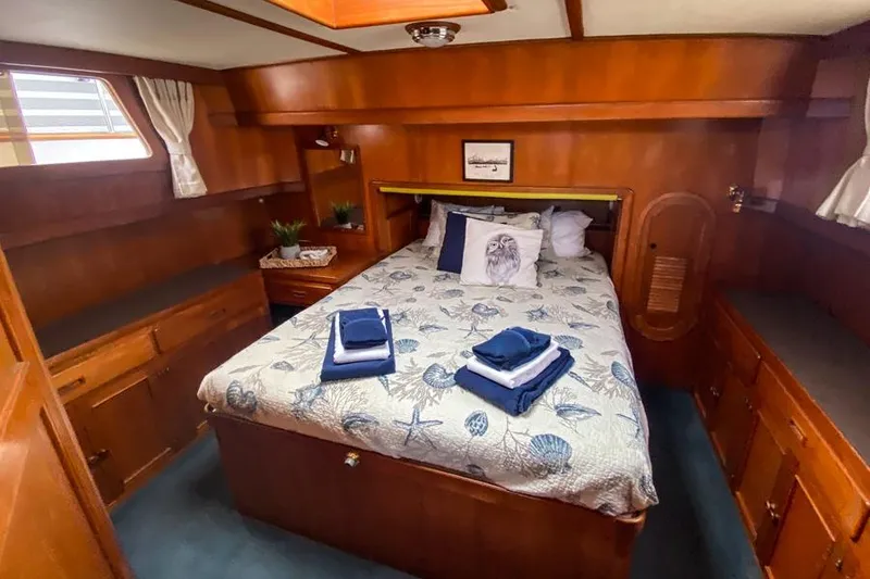 Slide: The Image of 1980 CHB Trawler cabin with cozy bed, wooden interior, and nautical decor. - 7