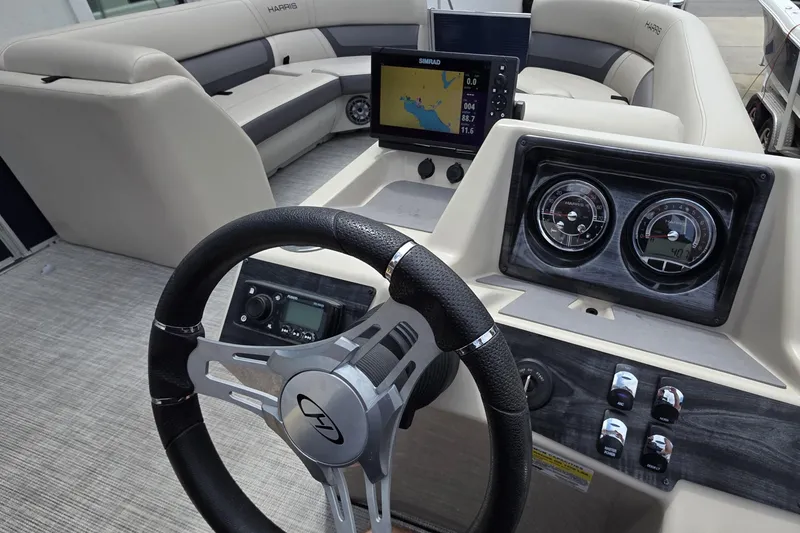 Slide: The Image of 2021 Harris Cruiser 230 boat dashboard with steering wheel, gauges, and navigation display. - 10