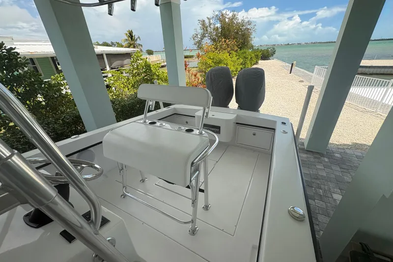 Slide: The Image of 2025 Whitewater 28 boat docked, featuring sleek design and dual engines, with scenic waterfront view. - 11