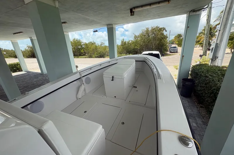 Slide: The Image of 2025 Whitewater 28 boat under shelter, showcasing spacious deck and seating area. - 13