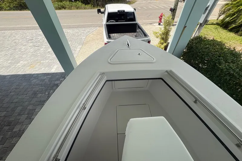 Slide: The Image of 2025 Whitewater 28 boat on trailer, parked near a pickup truck, viewed from above. - 15